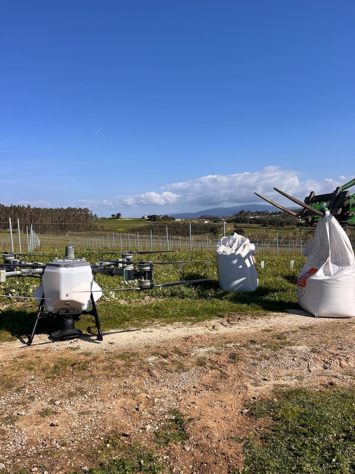 Drone Sky Agro pronto para uma adubação, com os sacos de adubo ao lado