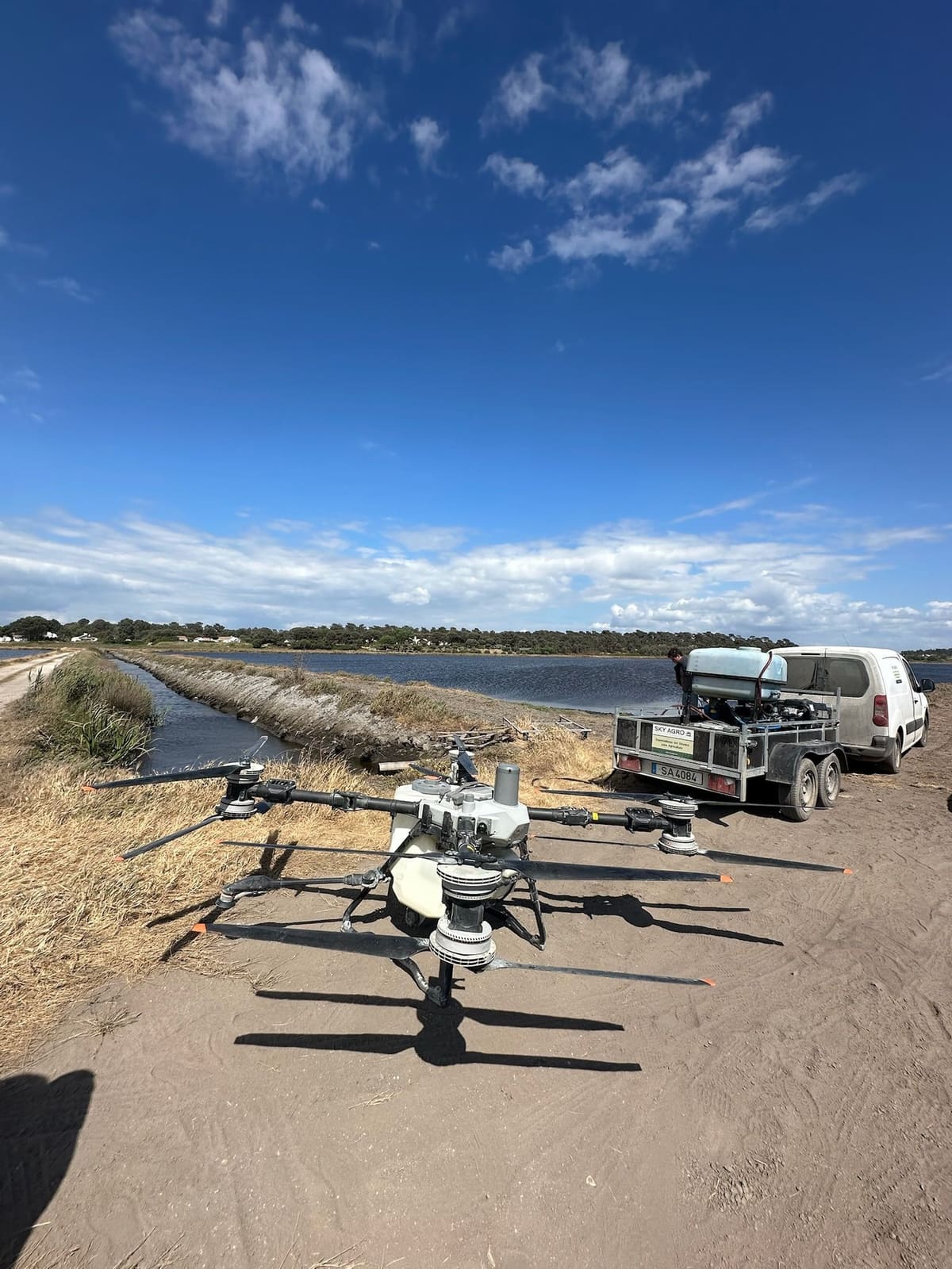 Drone Sky Agro junto a um arrozal, com o reboque de apoio